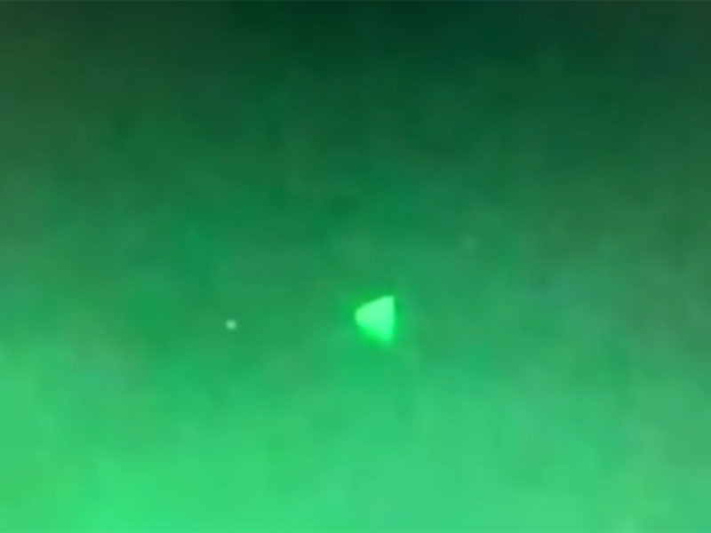Screenshot of leaked video of a triangular-shaped UFO hovering above the USS Russell Navy Destroyer.